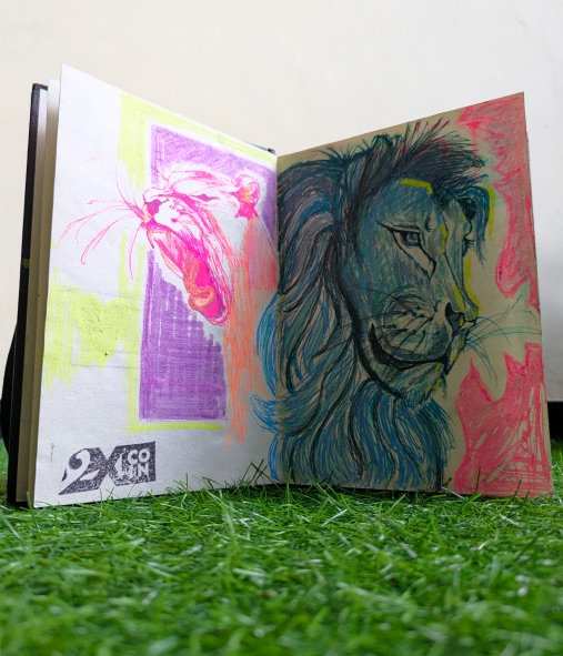 Open sketchbook with two lion drawings and a 2XCOIN stamp